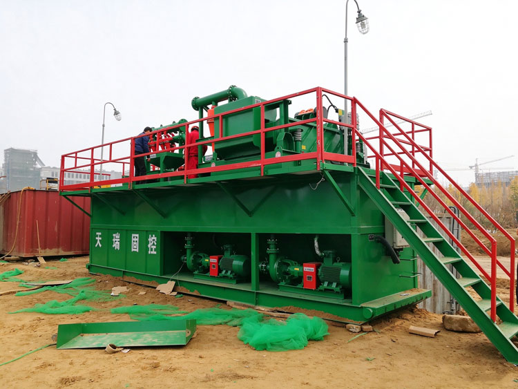 Geothermal drilling mud recovery system with feed pumps and piping in the lower tank compartment.